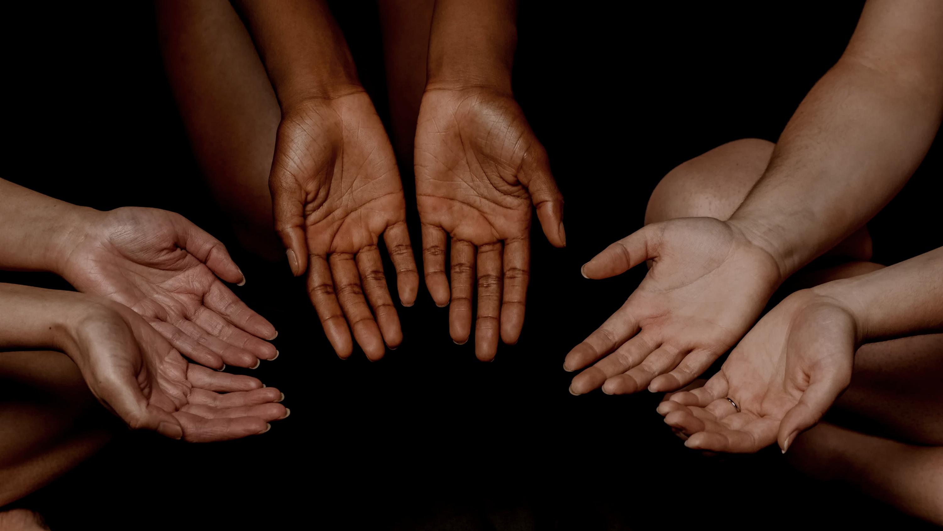 Open hands reaching together in unity — Mrs. Sally's House community